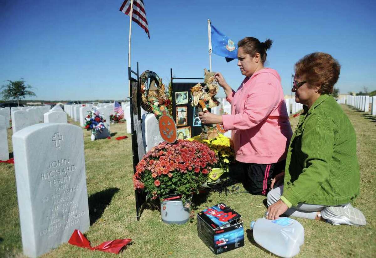 Anselma Trinidad and her daughter, Bianca Reyes, decorate the grave of her husband, Marines and Air Force veteran Israel Trinidad, who died in January. They visited the Fort Sam Houston National Cemetery on Veterans Day, Nov. 11, 2011.
