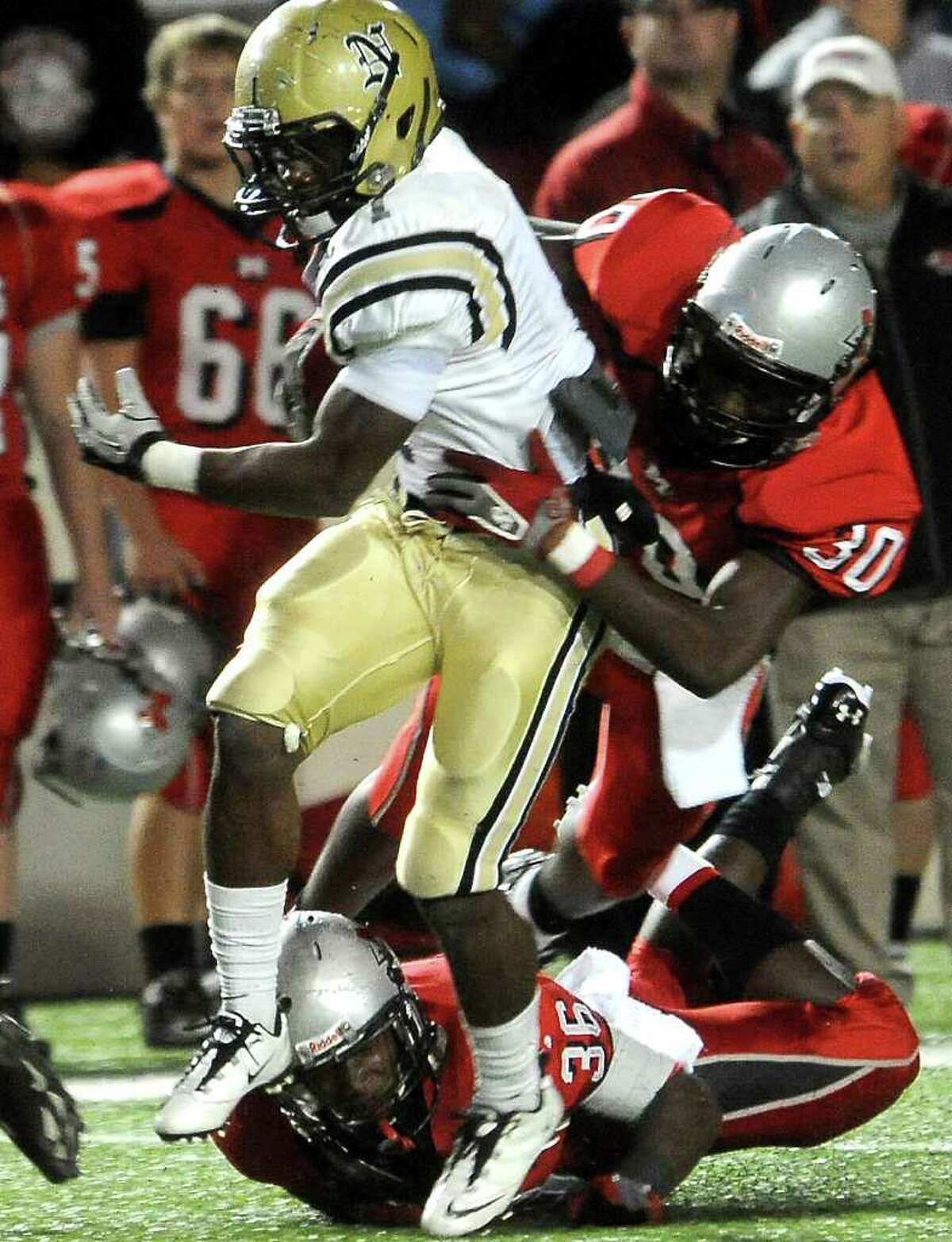 Nederland's Troy Benjamin is almost brought down by Goose Creek's Josh Mayes at the Provost Umphrey Stadium at Lamar University in Beaumont, Friday, November 11, 2011. Tammy McKinley/The Enterprise