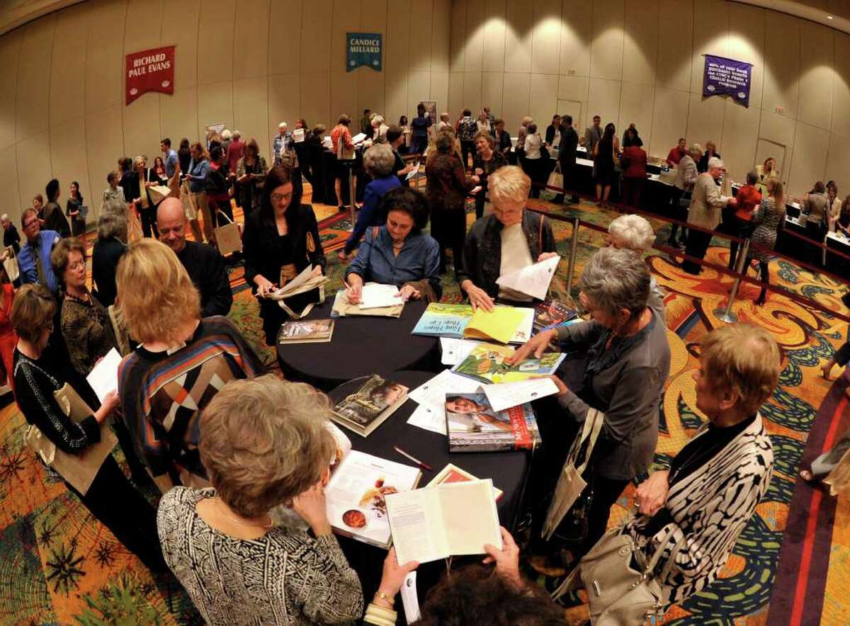 People attending the 20th Annual San Antonio Express-News Book and Author Luncheon look over their books at a center table inside the Marriott Rivercenter Hotel Monday morning.