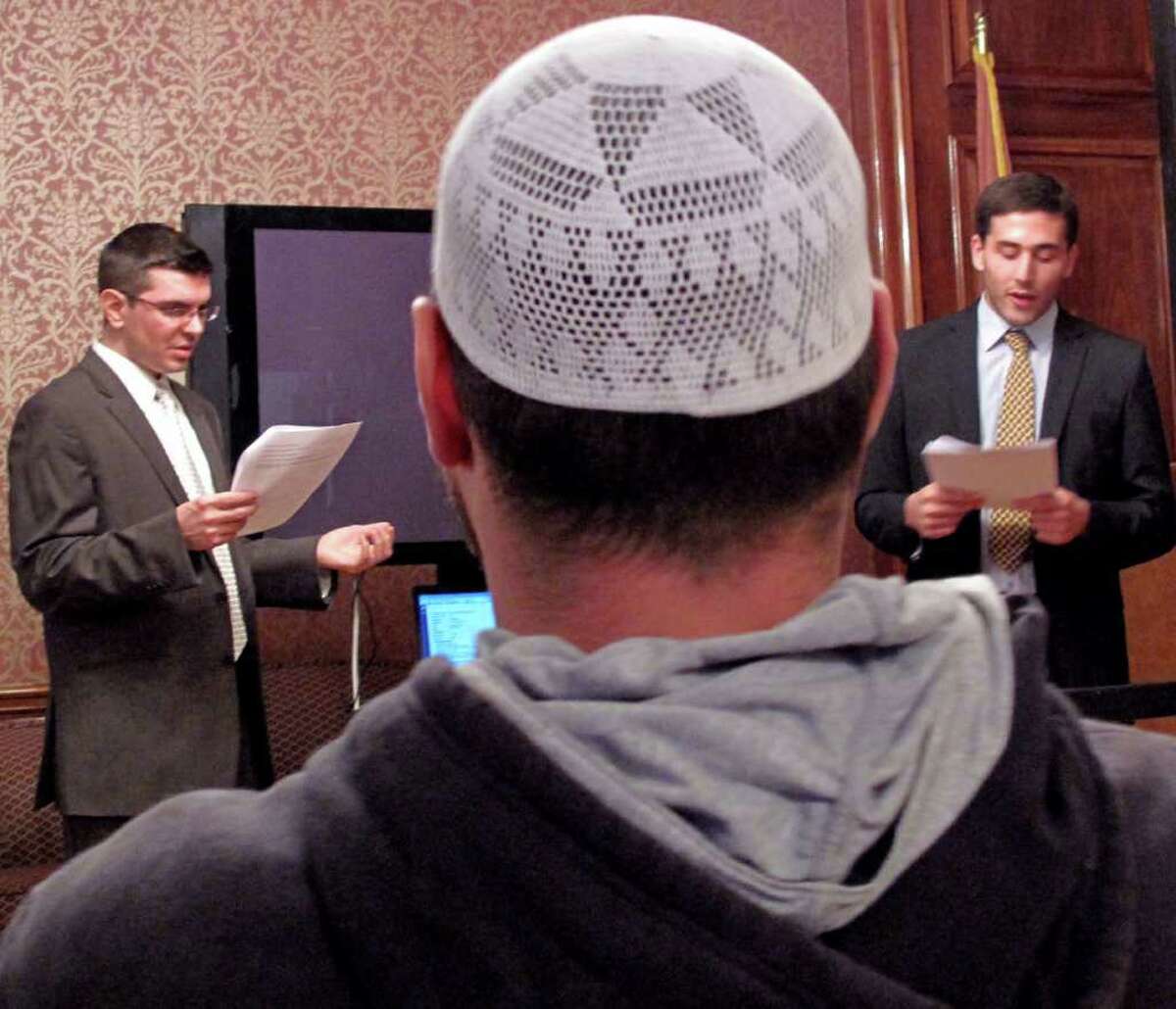 In this Oct. 26, 2011, photo, Joseph Ramagli, left and Robin Gordon-Leavitt, law students at the City University of New York, teach a group of Muslims in the Brooklyn borough of New York how to identify a police informant. They were acting out an actual transcript of a recorded conversation between a police informant and his target. in the Brooklyn borough of New York, teach them about their rights in regard to an NYPD surveillance program targeting Muslims. Fed up with a decade of the police spying on the innocuous details of the daily lives of Muslims, activists in New York are discouraging people from going directly to police with concerns about terrorism, a campaign that is certain to further strain relations between the two groups. Muslim community leaders are openly teaching people how to identify police informants, encouraging them to always talk to an attorney before speaking with authorities and reminding people already working with law enforcement that they have the right to change their minds. (AP Photo/Chris Hawley)