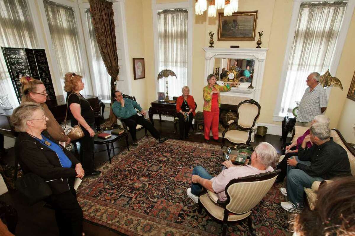 Carter archivist Marlene Richardson (standing center) tells memberes of the Helotes Historical Society about the Maverick-Carter House during their tour of house at 119 Taylor St. on Monday. The house was built in 1893 by architect Alfred Giles for William Maverick and purchased in approximately the early 1900's by Henry Champe Carter.
