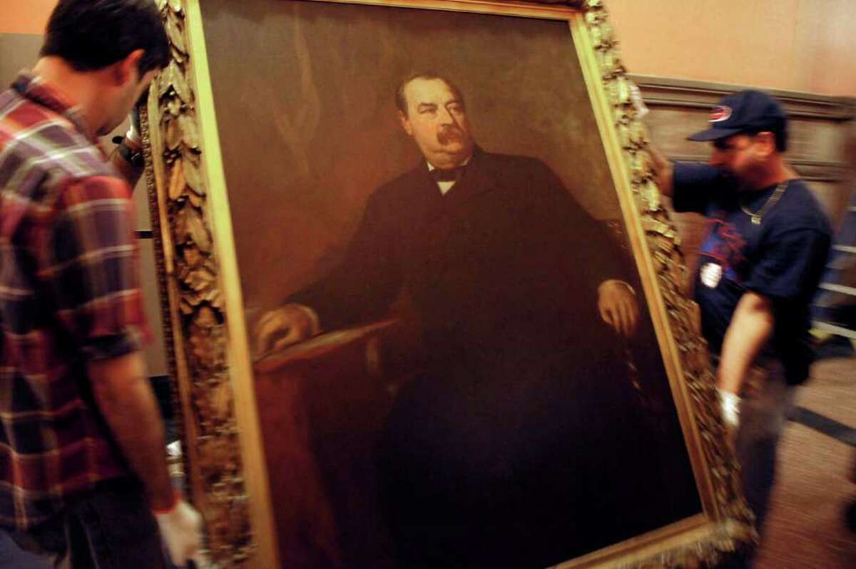 A painting of Grover Cleveland is placed onto a cart as workers from the State Museum and OGS removed the paintings of past governors from the walls in the Hall of Governors on the second floor of the capitol on Tuesday, Nov. 15, 2011. (Paul Buckowski / Times Union)
