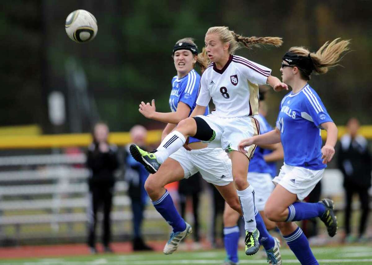 St. Joseph's Samantha Grasso takes a shot between Lewis Mills defenders, Lesleigh Carter, left, and Alison Hannon, right, during the Class M girls soccer quarterfinal match Tuesday, Nov. 15, 2011 at St. Joseph High School in Trumbull, Conn.