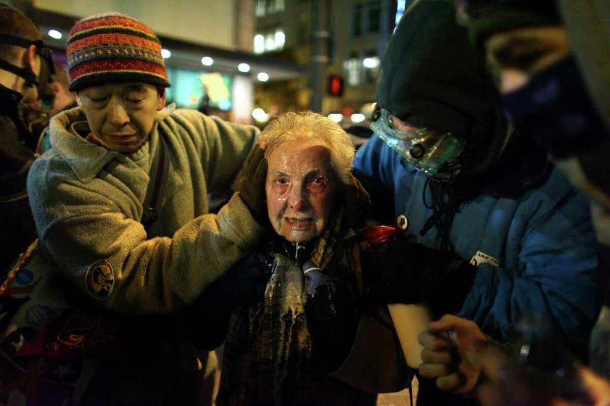 Seattle activist Dorli Rainey, 84, reacts after being hit with pepper spray during an Occupy Seattle protest on Tuesday, November 15, 2011 at Westlake Park. Protesters gathered in the intersection of 5th Avenue and Pine Street after marching from their camp at Seattle Central Community College in support of Occupy Wall Street. Many refused to move from the intersection after being ordered by police. Police then began spraying pepper spray into the gathered crowd hitting dozens of people. A pregnant woman was taken from the melee in an ambulance after being struck with spray.