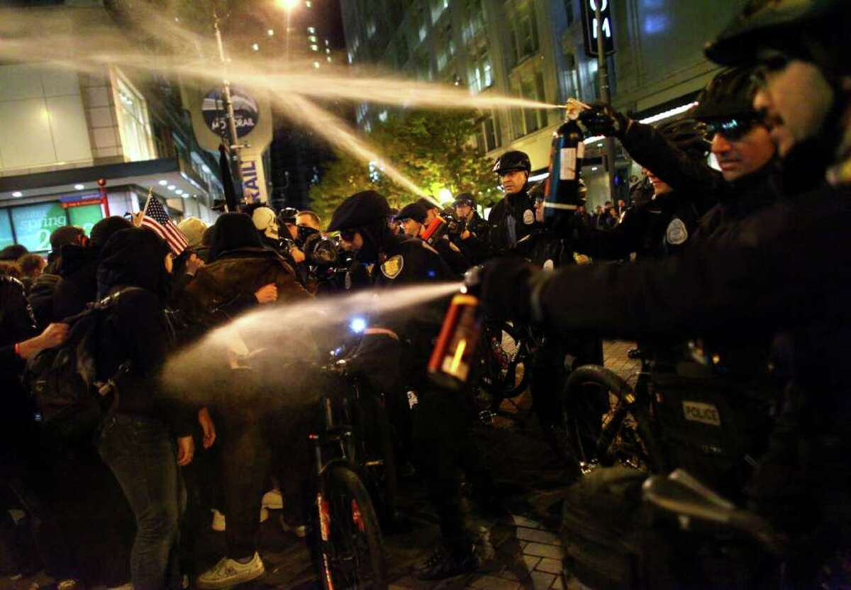 Seattle Police officers deploy pepper spray into a crowd during an Occupy Seattle protest on Tuesday, November 15, 2011 at Westlake Park.