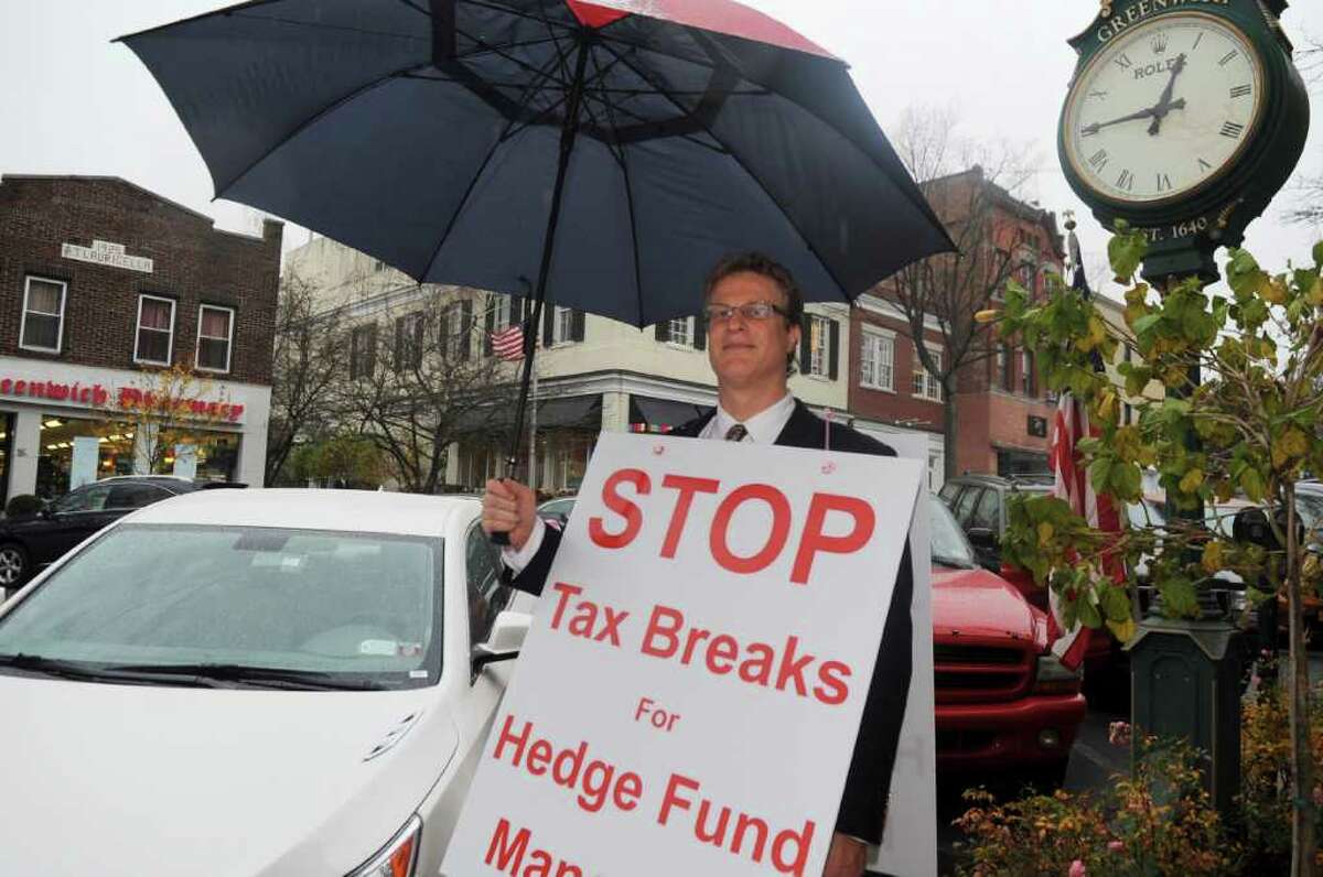 Daniel Barach of Mamaroneck, N.Y., a portfolio manager consultant, walks up and down Greenwich Avenue Wednesday afternoon Nov. 16, 2011, to protest hedge funds.