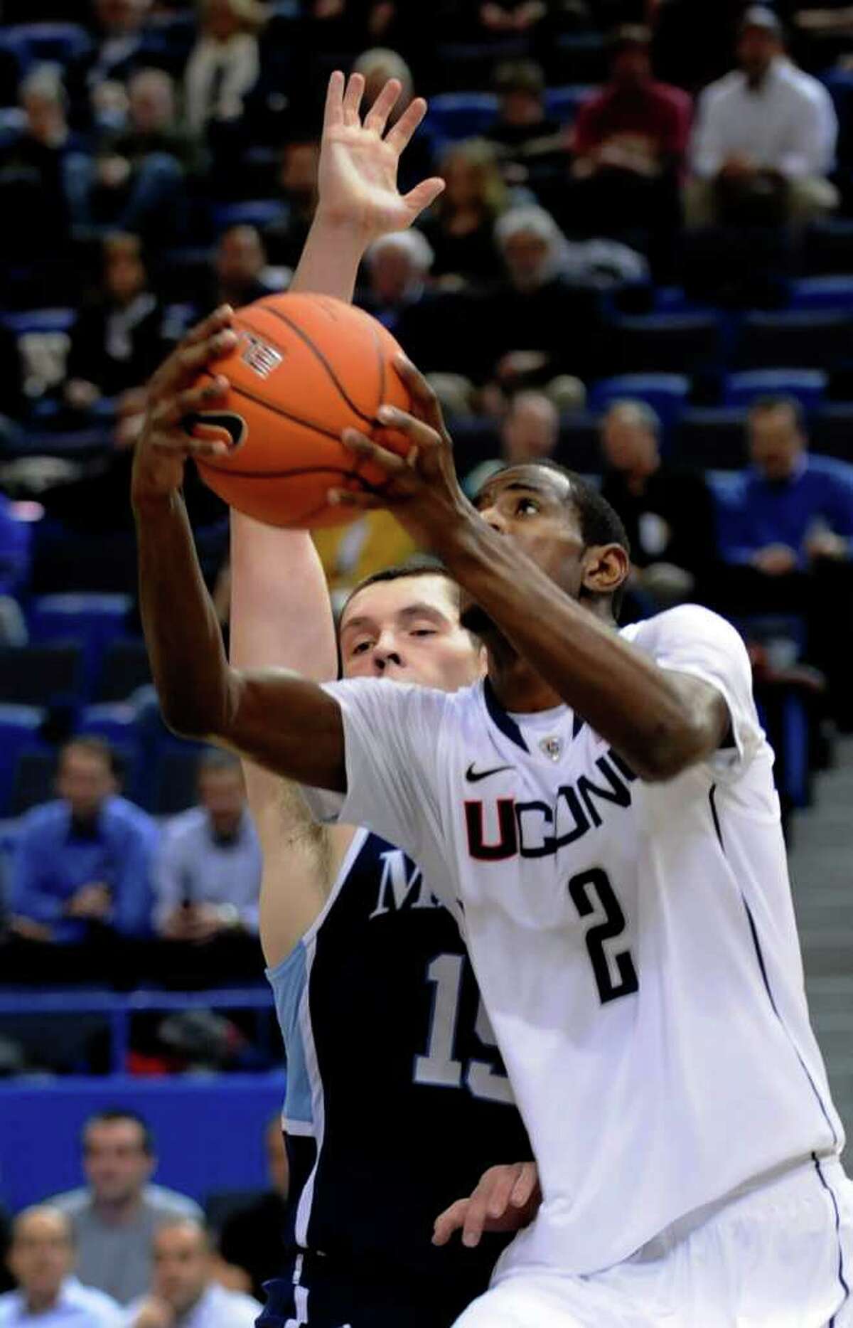Connecticut's DeAndre Daniels goes up past Maine's Alasdair Fraser for a shot in the first half of an NCAA college basketball game in Hartford, Conn., Thursday, Nov. 17, 2011. (AP Photo/Bob Child)