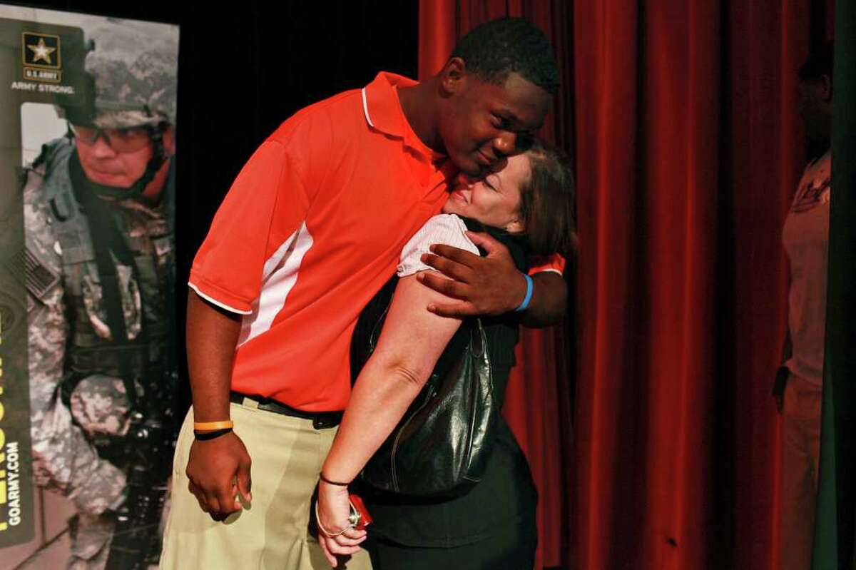 Javonte Magee hugs Clarice Caldwell, his tutor and "second mother," as he calls her, after he formally accepted his invitation to play in the U.S. Army All-American Bowl at Sam Houston High School in San Antonio on Wednesday, Nov. 16, 2011.