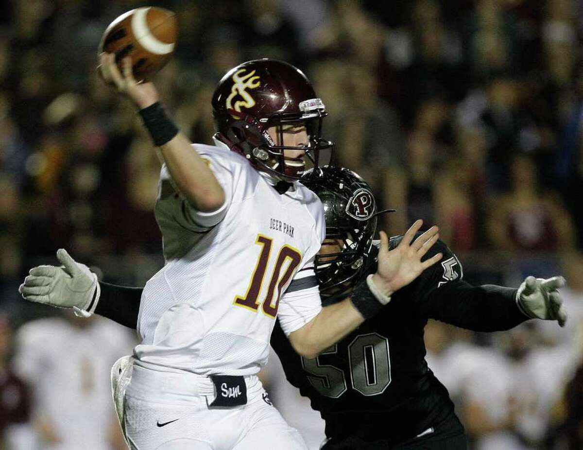 11/18/11: Quarterback Austin Rainer (10) of the Deer Park Deer passes the ball before getting hit hard by lineman Ashton Duffy (50) of the Pearland Oilers in an area high school football playoff game at GPISD Stadium in Houston, Texas.