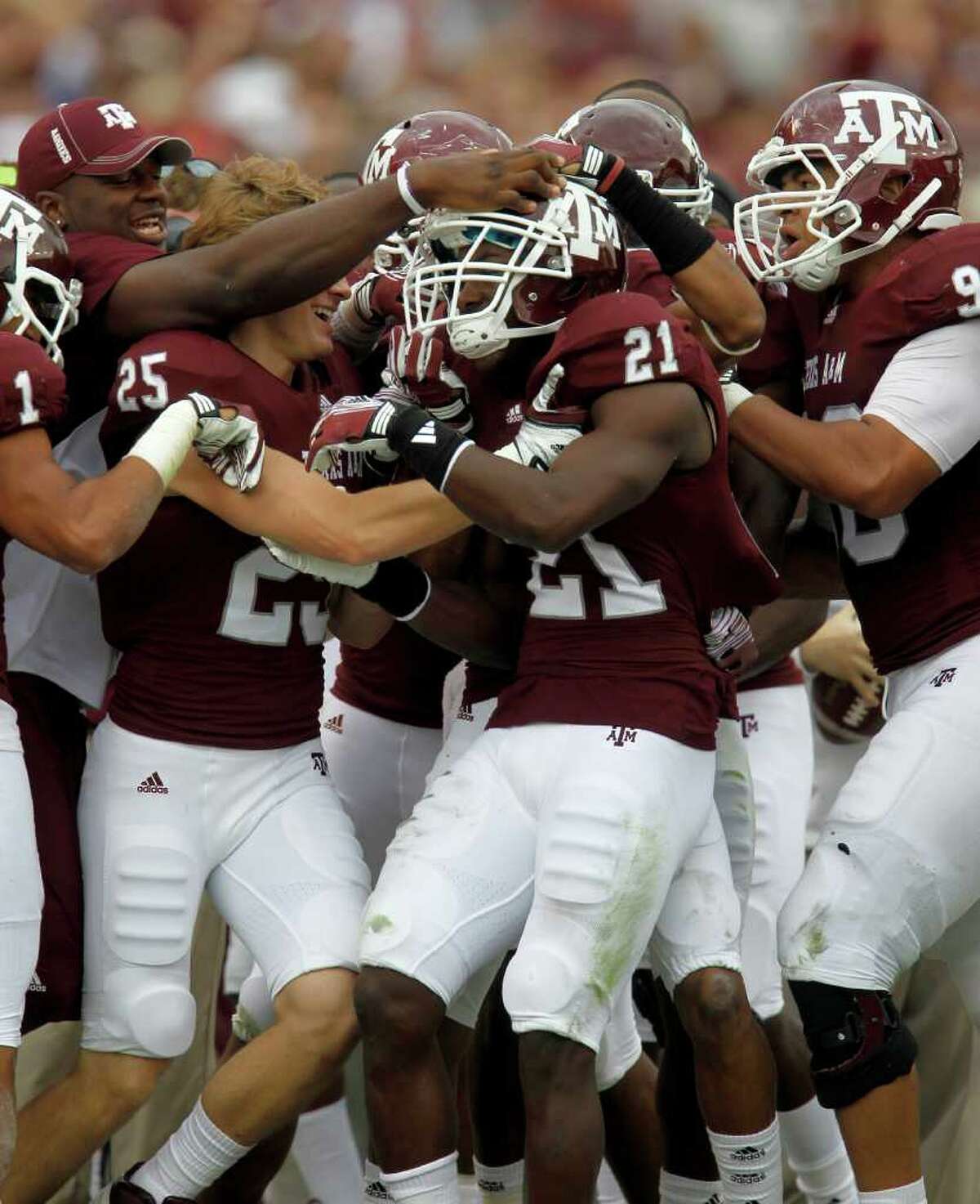 Texas A&M players mob Texas A&M Aggies defensive back Steven Terrell (21) after his interception in the second quarter of the college football game at Texas A&M, Nov. 19, 2011. Texas A&M was leading Kansas 44-0 at the half.