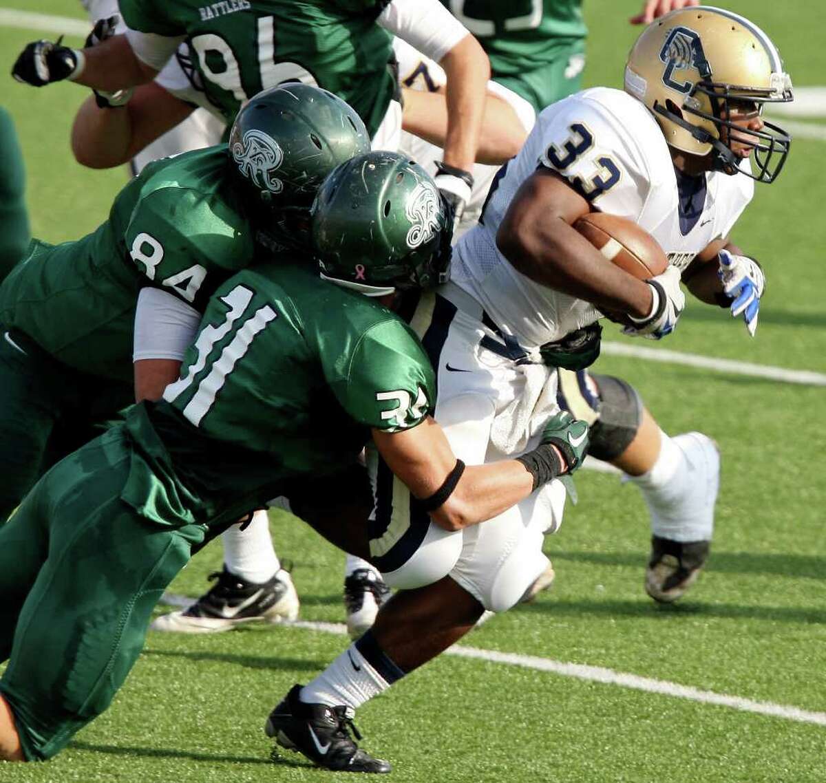 O'Connor's Brandon Twillie tries to shake the tackle of Reagan's Will Speck (left) and Reagan's Daerek Wilson during first half action of their Class 5A Division II playoff game Saturday Nov. 19, 2011 at Heroes Stadium.