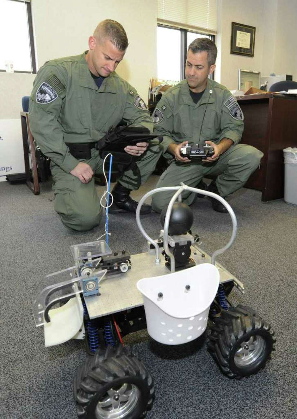 Albany Police Officers Ken Koonz, left and Hayden Butterfield of the Emergency Response Team show off the robotic machine at the Public Safety building in Albany, N.Y. November 17, 2011. The Low Cost Surveillance Unit uses an onboard camera to seek out assailants in a barricade or hostage situation. (Skip Dickstein/Times Union)