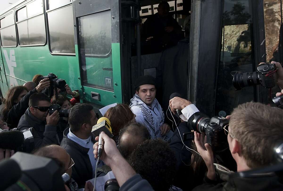 Reporters surround a Palestinian activist as he boards an Israeli bus outside the West Bank Jewish settlement of Migron, near Ramallah, on November 15, 2011. Palestinian "Freedom Riders" reenacted US civil rights movement's boarding of segregated buses in the American south by riding Israeli settler buses to Jerusalem. Several Israeli transportation companies operate dozens of lines that run through the occupied West Bank and east Jerusalem, many of them subsidized by the state. While it is not officially forbidden for Palestinians to use Israeli public transportation in the West Bank, these lines are effectively segregated, since many of them pass through Jewish-only settlements, to which Palestinian entry is prohibited by a military decree. AFP PHOTO/AHMAD GHARABLI (Photo credit should read AHMAD GHARABLI/AFP/Getty Images)