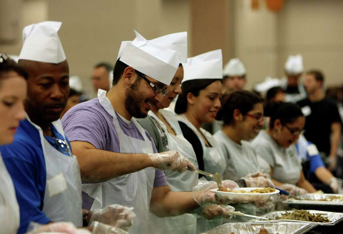 Volunteers prepare plates during the 32nd annual Raul Jimenez Thanksgiving Dinner, Nov. 24, 2011, at the Convention Center.