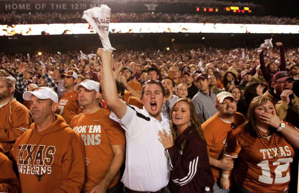Texas fans Chad White and Shane White, left, of Corpus Christi, Texas A&M fans Tyler Beam, center left, of Falls City, Genna Kopecki, of Karnes City, and Texas fans Chris and Shauna Stewart, far right, of Troup, react to a play near the end of the second quarter of an NCAA college football game at Kyle Field Thursday, Nov. 24, 2011, in College Station.