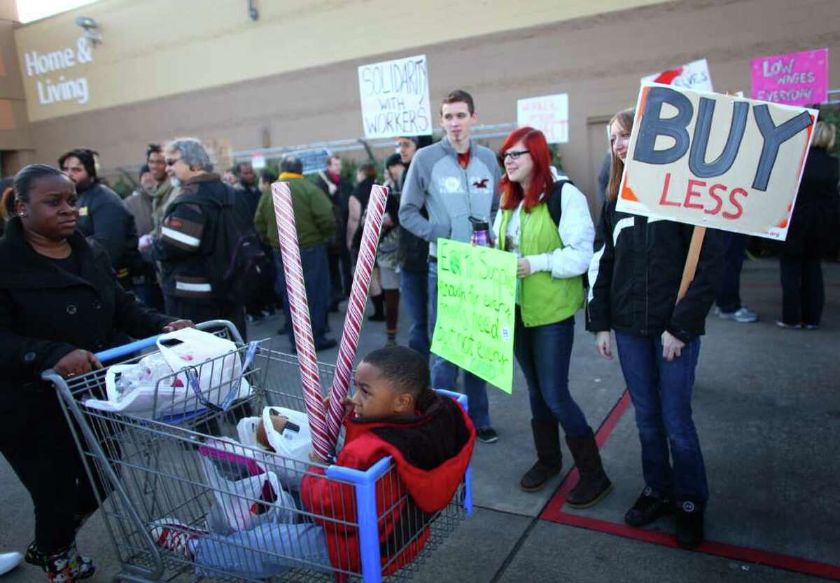Protesters gather in front of Walmart in Renton during an Occupy Seattle protest as customers leave the retailer on Black Friday.