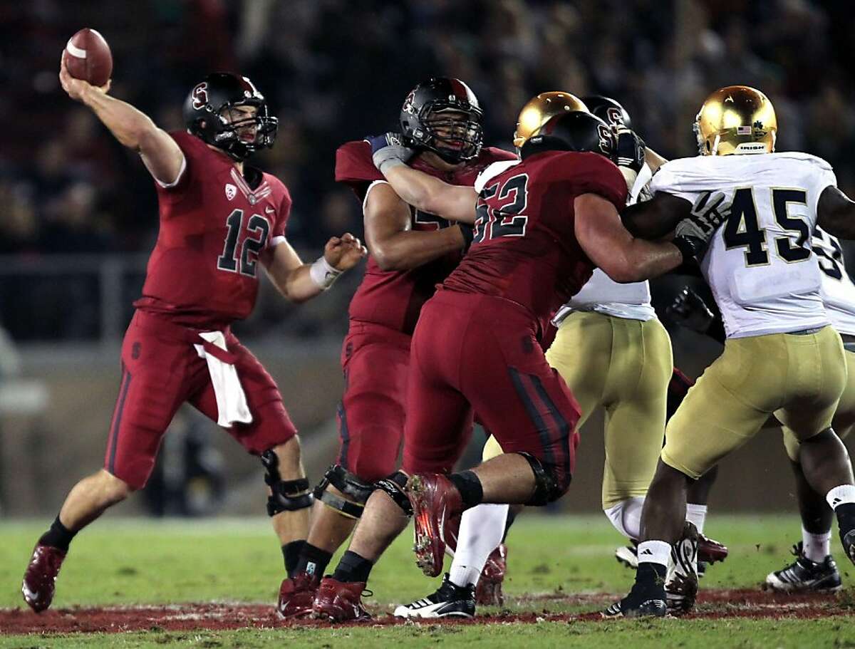 Stanford Cardinal quarterback Andrew Luck escapes the Notre Dame rush and completes a first quarter pass at Stanford Stadium on November 26 2011 in Stanford, California.The Cardinal defeated the Fighting Irish 28-14.
