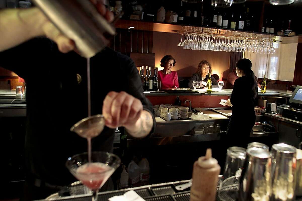 A waitress takes an order for dinner as a cocktail is strained at Millennium restaurant In San Francisco, Calif., on June 17th, 2011.