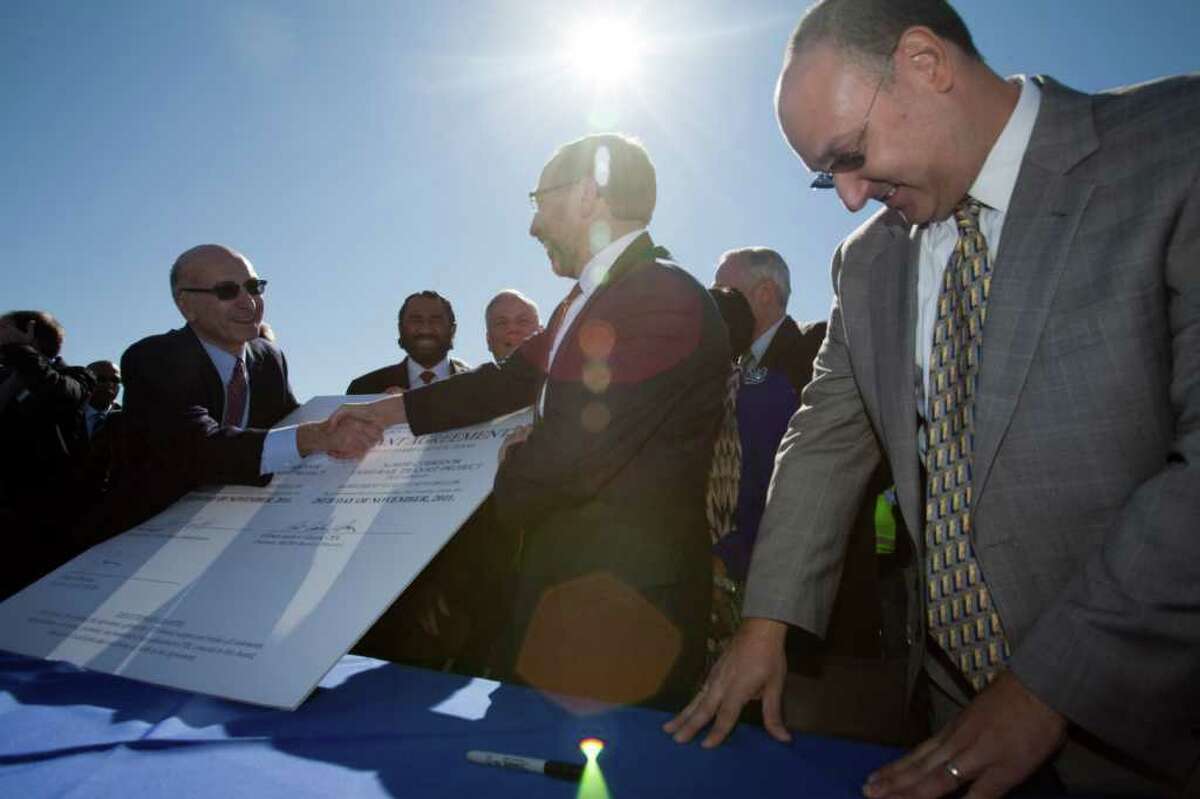 Metro CEO George Greanias, left, Federal Transit Administrator Peter Rogoff, and Metro chairman Gilbert Garcia symbolically signed a light rail grant for Metro totaling $900 million in 2011 in Houston.