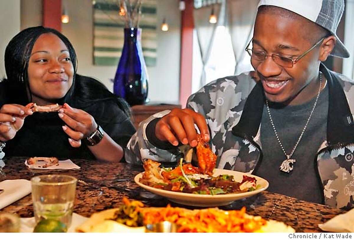 DINE25_0007_KW.JPG Maya Cuterry from Oakland and Shamar Cotton from Berkeley digs into a plate of chicken wings while sitting at the bar at Shashamane, an Ethiopian fusion cuisine restaurant in Oakland on April 18, 2007. Kat Wade/The Chronicle Maya Cuterry and Shamar Cotton (CQ, subject) Mandatory Credit for San Francisco Chronicle and photographer, Kat Wade, No Sales Mags out