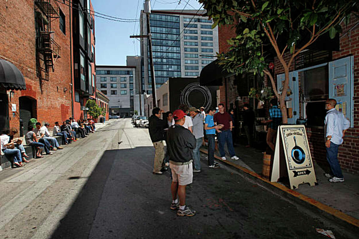 Little Skillet customers line up to order and eat in the alley way from this takeaway spot that serves southern favorites on Ritch alley in San Francisco, Calif., on August 7, 2009. Ran on: 08-20-2009 Little Skillet customers line up to order and eat in the alley way from this takeaway spot that serves southern favorites on Ritch alley in San Francisco.