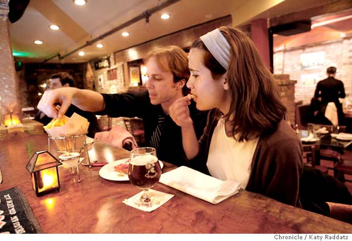 John Peterson, left, and Claire Scheidegger, right, enjoy a snack of fries at La Trappe, a Belgian restaurant and bar in North Beach, on Wednesday April 16, 2008, in San Francisco, Calif. Photo by Katy Raddatz / San Francisco Chronicle Ran on: 04-23-2008 John Peterson (left) and Claire Scheidegger share fries and beer at La Trappe in North Beach.