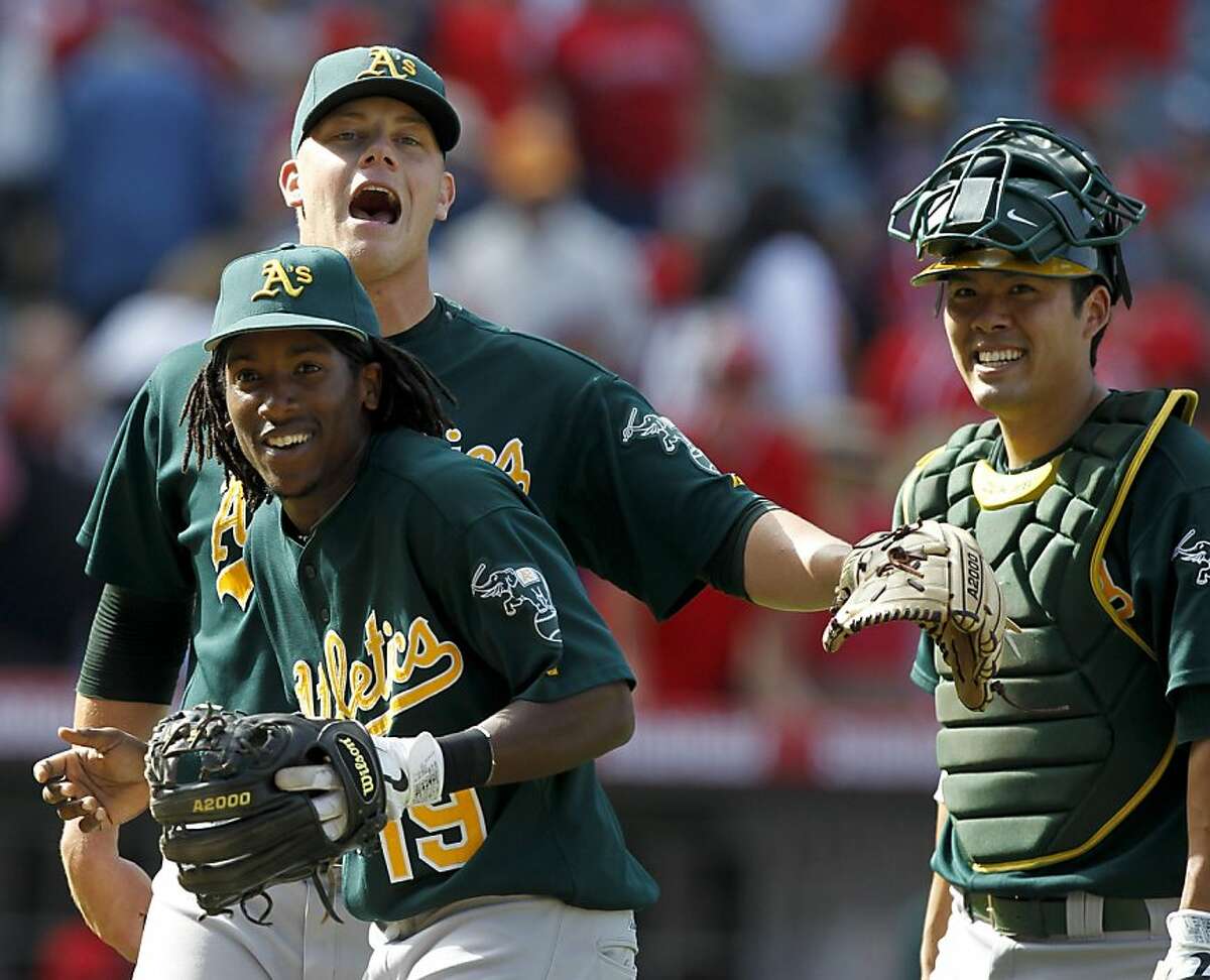 Oakland Athletics second baseman Jemile Weeks, from left, relief pitcher Andrew Bailey and catcher Kurt Suzuki celebrates their win against the Los Angeles Angels during a baseball game in Anaheim, Calif., Sunday, Sept. 25, 2011. (AP Photo/Chris Carlson)