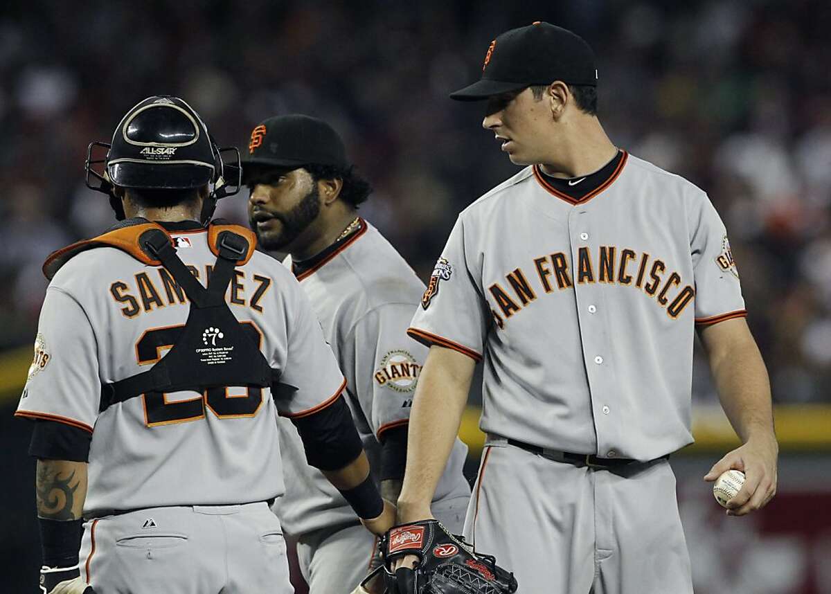 San Francisco Giants' Eric Surkamp, right, looks back at teammates Pablo Sandoval, center, and Hector Sanchez after they visited Surkamp on the mound during the first inning of a baseball game against the Arizona Diamondbacks Saturday, Sept. 24, 2011, in Phoenix. (AP Photo/Ross D. Franklin)