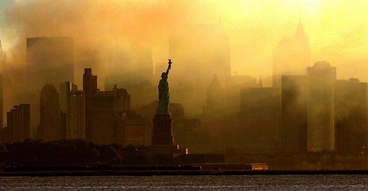 The Statue of Liberty is seen at first light in this view from Jersey City, N.J., against a smoke-filled backdrop of the lower Manhattan skyline, early Saturday, Sept. 15, 2001.
