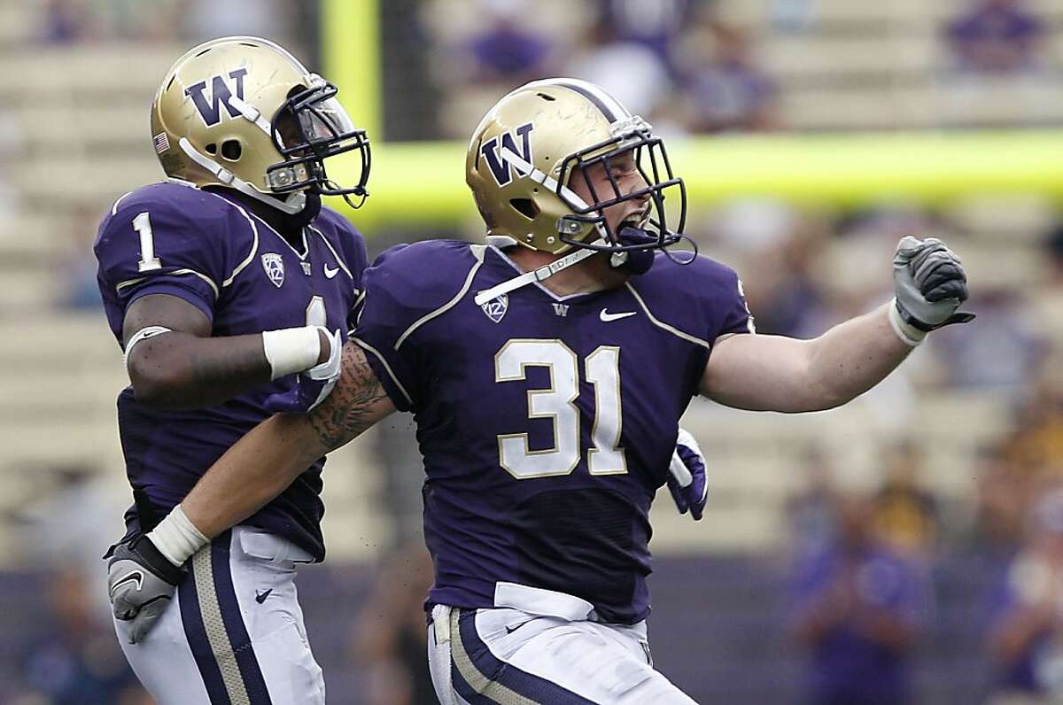 Washington's Sean Parker (1) celebrates with Cort Dennison after Dennison broke up a fourth down pass by California in the second half of an NCAA football game, Saturday, Sept. 24, 2011, in Seattle. Washington won 31-23. (AP Photo/Elaine Thompson)