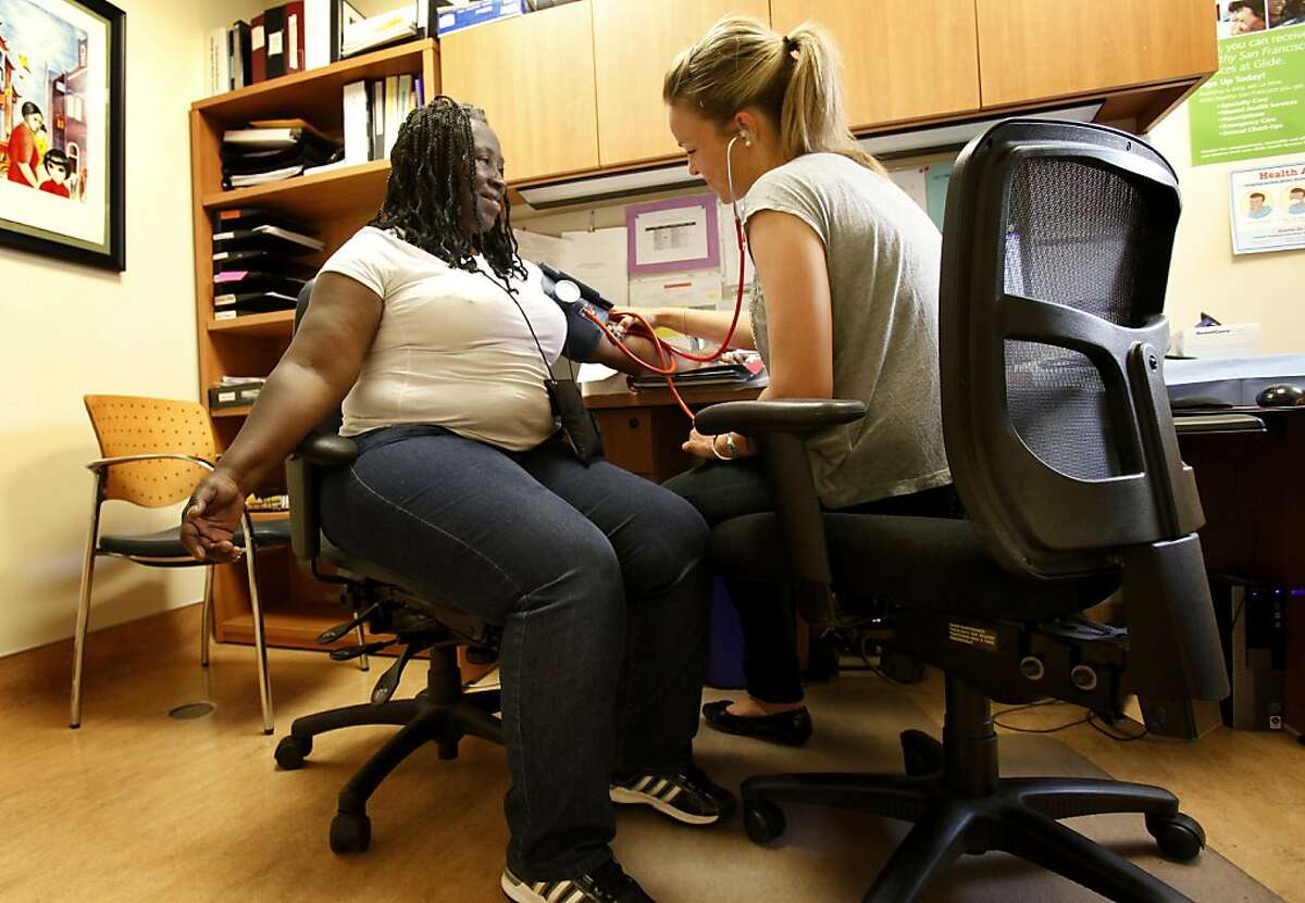 SF Empower volunteer Brittany Wilson (right) checks the blood pressure of diabetic Veronica Patterson. A new program developed by two nurses from UCSF is helping people in San Francisco, Calif. with mental issues deal with diabetes. The program is administered at Glide Health Services.