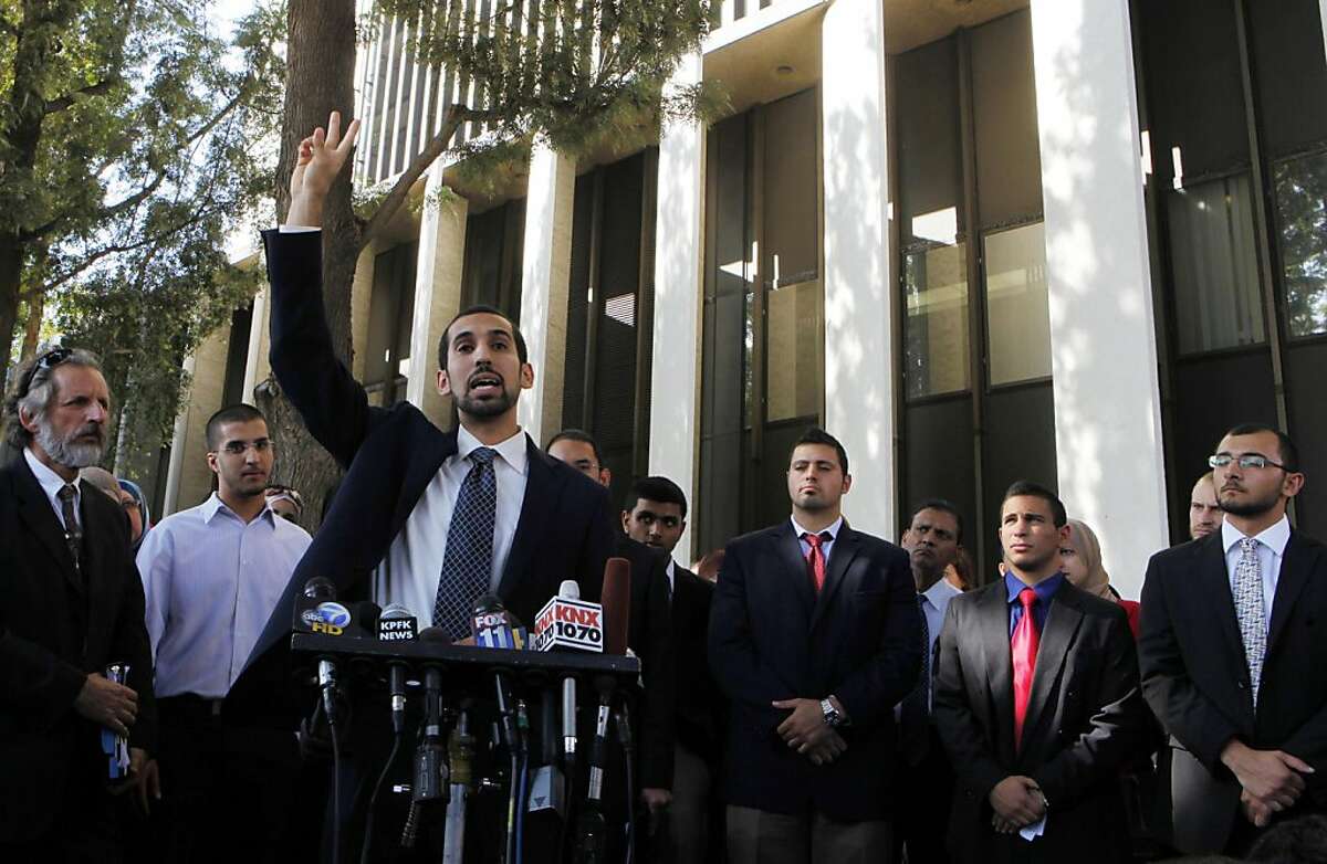 Student Mohamad Abdelgany, at podium, raises his hand as his fellow students and other supporters take questions from the media after being convicted in Santa Ana, Calif., Friday, Sept. 23, 2011. A California jury on Friday convicted 10 Muslim students of illegally disrupting a speech by Israeli Ambassador Michael Oren at the University of California, Irvine, last year, including Abdelgany, in a case that has stoked an intense debate about free speech. (AP Photo/Damian Dovarganes)