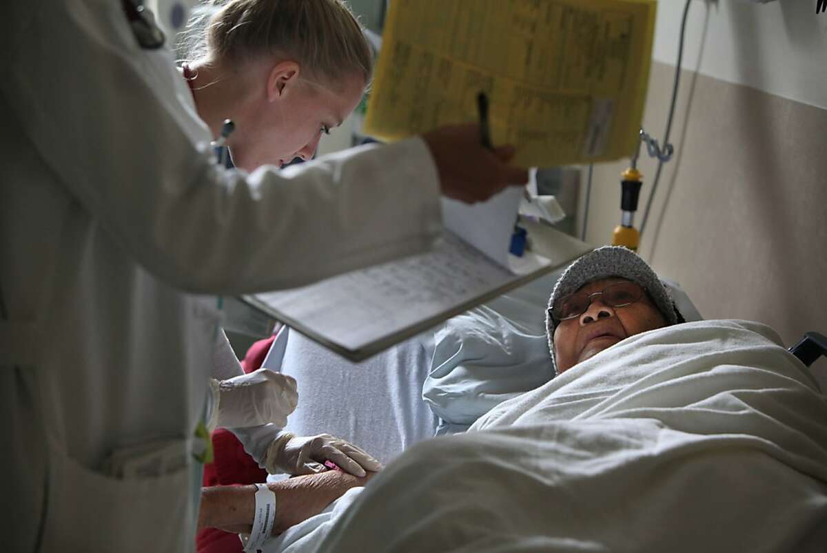 Lenora Macam (right) answers Dr. Aparajita Sohoni (left) while RN Lauren Bowles (center) administers an IV to Macam in Exam Room 7 at the St. Luke's Hospital Emergency Room on Thursday, September 15, 2011 in San Francisco, Calif.
