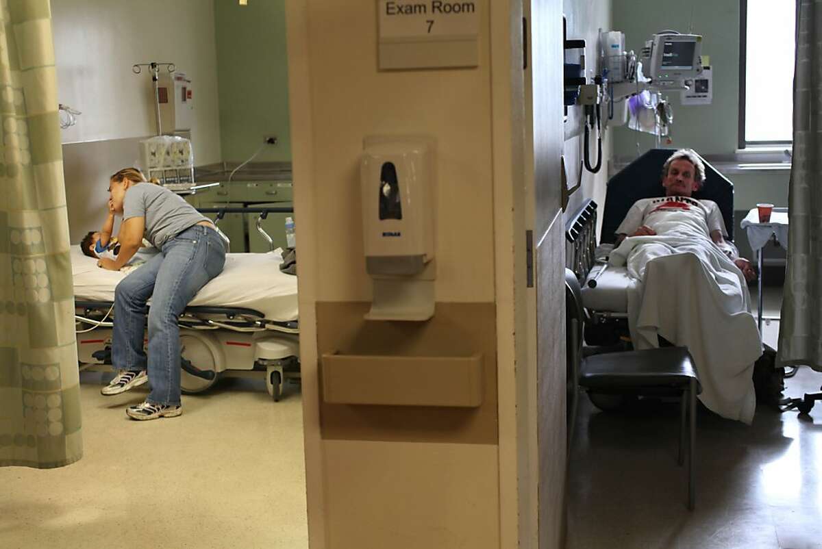 Rosa Gonzalez (second from left) tends to her son Roger, 8 months, Gonzalez at the St. Luke's Hospital Emergency Room while Roy Hinchee (right) waits in Exam Room 7 at the Saint Luke's Emergency Room on Thursday, September 15, 2011 in San Francisco, Calif.