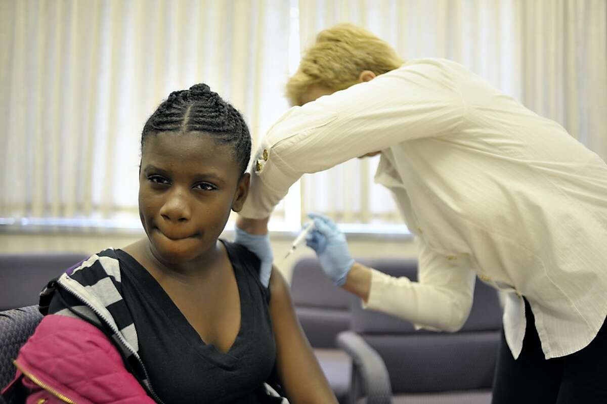 SEPTEMBER 15, 2011-VACCINE16-At San Francisco Unified school DIstrict headquarters, students are immunized against whooping cough. Joenisha Johnson, 11, of Visitacion Valley Middle School receives the injection.