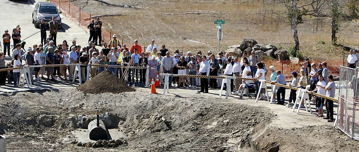 Residents of the San Bruno Crestmoor neighborhood stand with the Mayor and other officials at the corner of Glenview Drive and Earl for a ceremonial shoveling of dirt to start filling the crater which was created by the PG&E pipeline explosion, Tuesday September 20, 2011, in San Bruno, Calif.