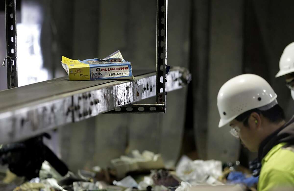 Jason Naraja, a worker of Recycle Central sorts out the phonebooks from the other recycling and places them on a separate conveyor belt, Monday January 31, 2011, in San Francisco, Calif. Ran on: 02-01-2011 Robert Reed, top, of Recycle Central can find plenty of phone books among the piles of recyclables. Jason Naraja, above, moves them onto a separate conveyor belt. Ran on: 02-01-2011 Robert Reed, top, of Recycle Central can find plenty of phone books among the piles of recyclables. Jason Naraja, above, moves them onto a separate conveyor belt.
