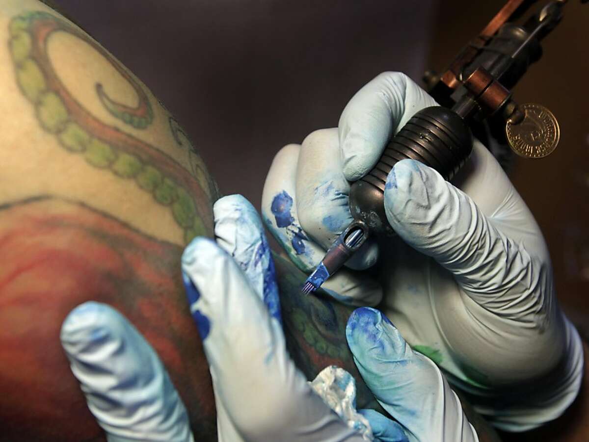 Mario Delgado (right) applies ink to a tattoo of an octupus for Vien Tang at the Moth and Dagger tattoo studio in San Francisco, Calif. on Saturday, Sept. 3, 2011. Tattoo studios are not required to post ingredients in the inks used but tattoo artist Delgado will provide them on request.