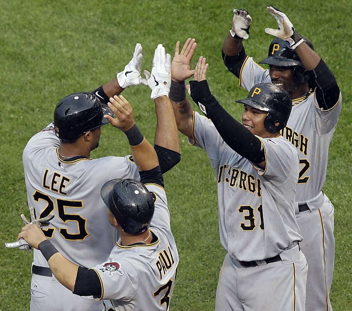 Pittsburgh Pirates' Derrek Lee (25) celebrates with teammates Xavier Paul (38), Jose Tabata (31) and Andrew McCutchen (22) after hitting a grand slam during the ninth inning of a baseball game against the Chicago Cubs on Saturday, Sept. 3, 2011, in Chicago. The Pirates won 7-5. (AP Photo/Nam Y. Huh)