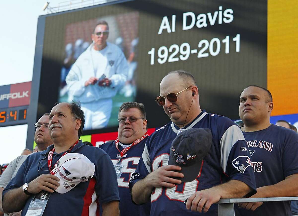 New England Patriots fans pause for a moment of silence in honor of Oakland Raiders owner Al Davis, who died Saturday, before the Patriots faced the New York Jets in an NFL football game in Foxborough, Mass., Sunday, Oct. 9, 2011. (AP Photo/Charles Krupa)