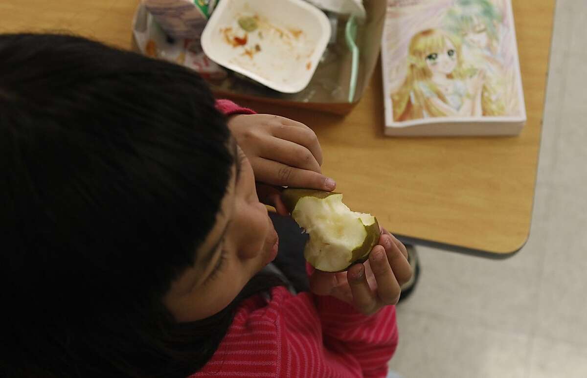 A student enjoys a pear during lunch in the cafeteria at Francisco Middle School on Tuesday, November 8, 2011 in San Francisco, Calif. According to a new report from the California Center for Public Health Advocacy, the percentage of overweight or obese children fell 1.1 percent from 2005 to 2010. Improvements in the San Francisco Unified School District (SFUSD) school meals include the improvement of it's vegetable offering by increasing the amount of dark green and orange vegetables. SFUSD meals which do not contain artificial flavoring or colors and and does not permit trans fats except for naturally occurring fats in beef and cheese, which are not considered a health risk. There are salad bars at all middle and high schools and elementary schools without salad bars serve a fresh pack of vegetables to its students and include fresh produce and whole grains each day.