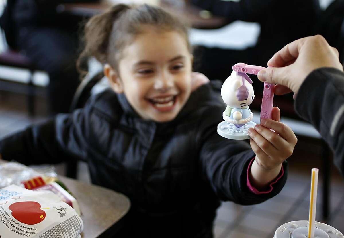 Hadara Chasky, 4-years-old reaches for her Hello Kitty toy from her brother as they eat their Happy Meals at ther McDonald's on the corner of 16th and Potrero streets in San Francisco, Ca., on Tuesday November 29, 2011. McDonald's is going to start charging customers for toys in Happy Meals starting December 1st of this year, as a way to comply with San Francisco's law that prohibits fast food restaurants from giving out free toys unless their meals meet strict standards.