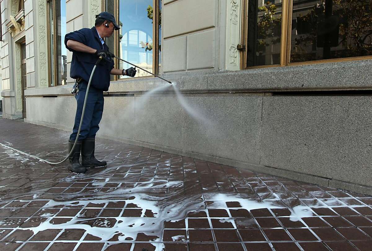 Gary Wong cleans off graffiti from the Westlake Building next to Frank Ogawa Plaza in Oakland Friday, November 4, 2011. The damage was part o0f the demonstrations earlier in the week.