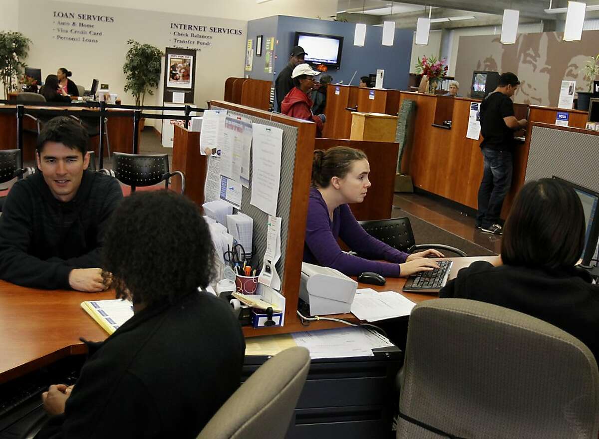 Sasha Hood (right) types in information for her new accounts at the credit union. She is shutting down her Wells Fargo accounts. Credit Unions like the Cooperative Center Federal Credit Union in Berkeley, Calif. are seeing more new customers transferring accounts from the more traditional big banks.