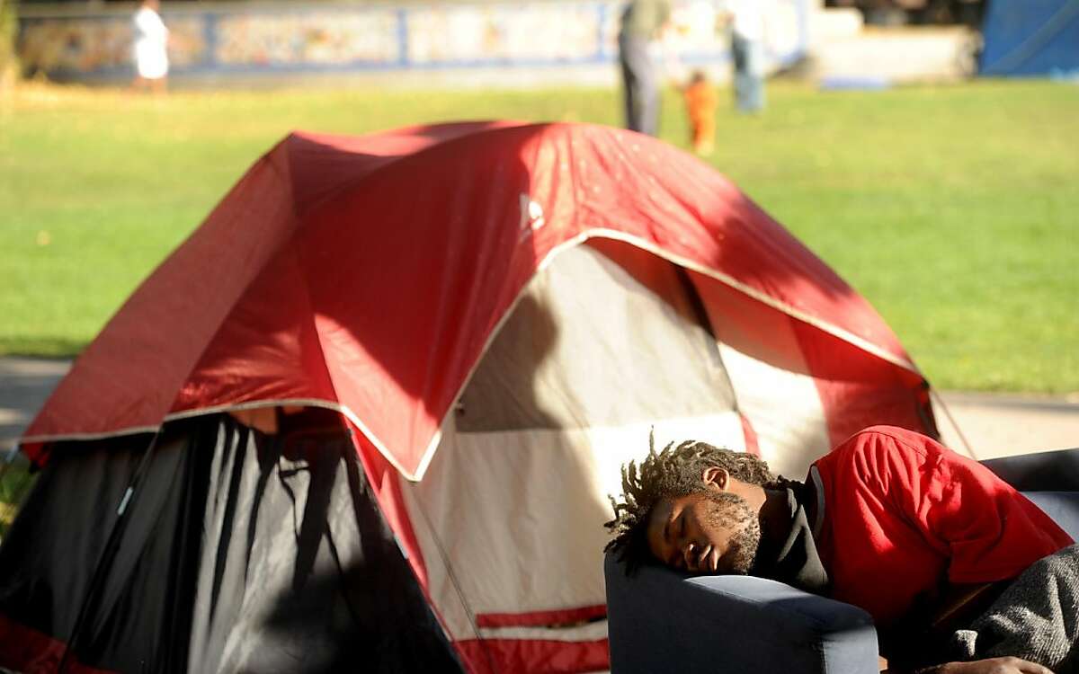 An unidentified Occupy Berkeley camper sleeps in front of a tent on Tuesday, Nov. 1, 2011, in Berkeley, Calif. As of Tuesday, about 30 tents dotted Civic Center Park.