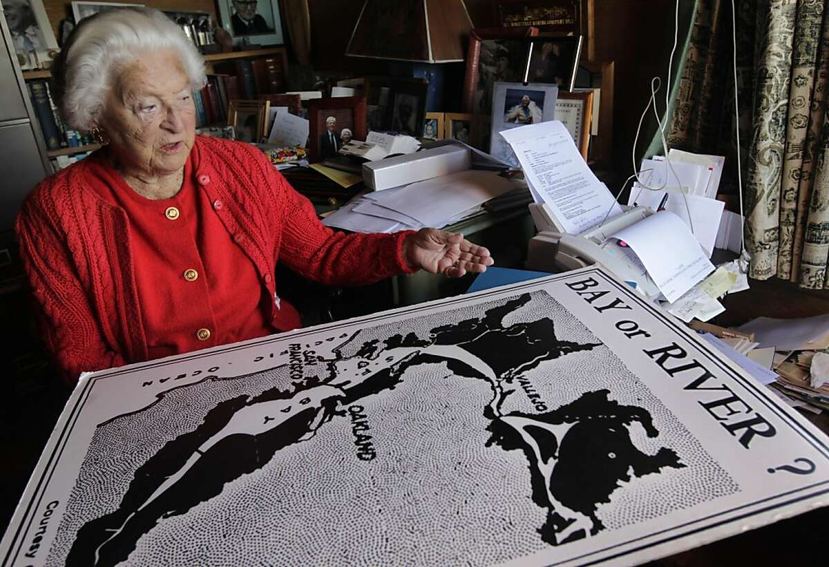 Sylvia McLaughlin, co-founder of the conservation group Save the Bay, looks at an old poster illustrating the potential shrinking of the bay at her home in Berkeley, Calif. on Saturday, Oct. 29, 2011. McLaughlin will be honored with a lifetime achievement award on the 50th anniversary of the organization she founded along with Esther Gulick and Kay Kerr.