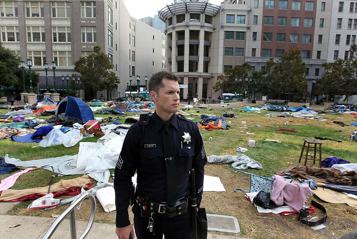 Oakland police officers walk amid possessions left behind by Occupy Oakland protestors across from City Hall Tuesday, Oct. 25, 2011, in Oakland, Calif. Occupy Oakland protestors were evicted from Frank H. Ogawa plaza early this morning.