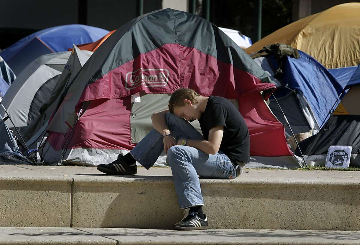 A young man rests on the steps of Frank Ogawa Plaza in front of the Occupy Oakland tent city at City Hall in Oakland, Calif. on Tuesday, Oct. 18, 2011. A second encampment is now set up at Snow Park across from Lake Merritt.