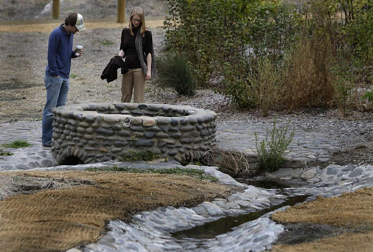 Visitors look inside the commemorative well at the newly restored El Polin Springs area of the Presidio in San Francisco, Calif. on Thursday, Oct. 20, 2011. The Presidio Trust recently completed a project that "daylighted" three hundred feet of the creek, which had been buried in pipes for decades and now feeds several wetlands ponds.