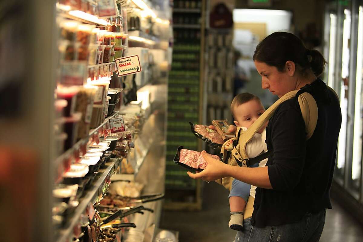 Lisa Brady of San Francisco selects groceries at Bi-Rite Market with her son, Oliver, 5 months, at Bi-Rite Market in San Francisco, Calif. on Monday November 23, 2009. Ran on: 11-26-2009 Lisa Brady of San Francisco selects groceries at Bi-Rite Market with her 5-month-old son, Oliver.